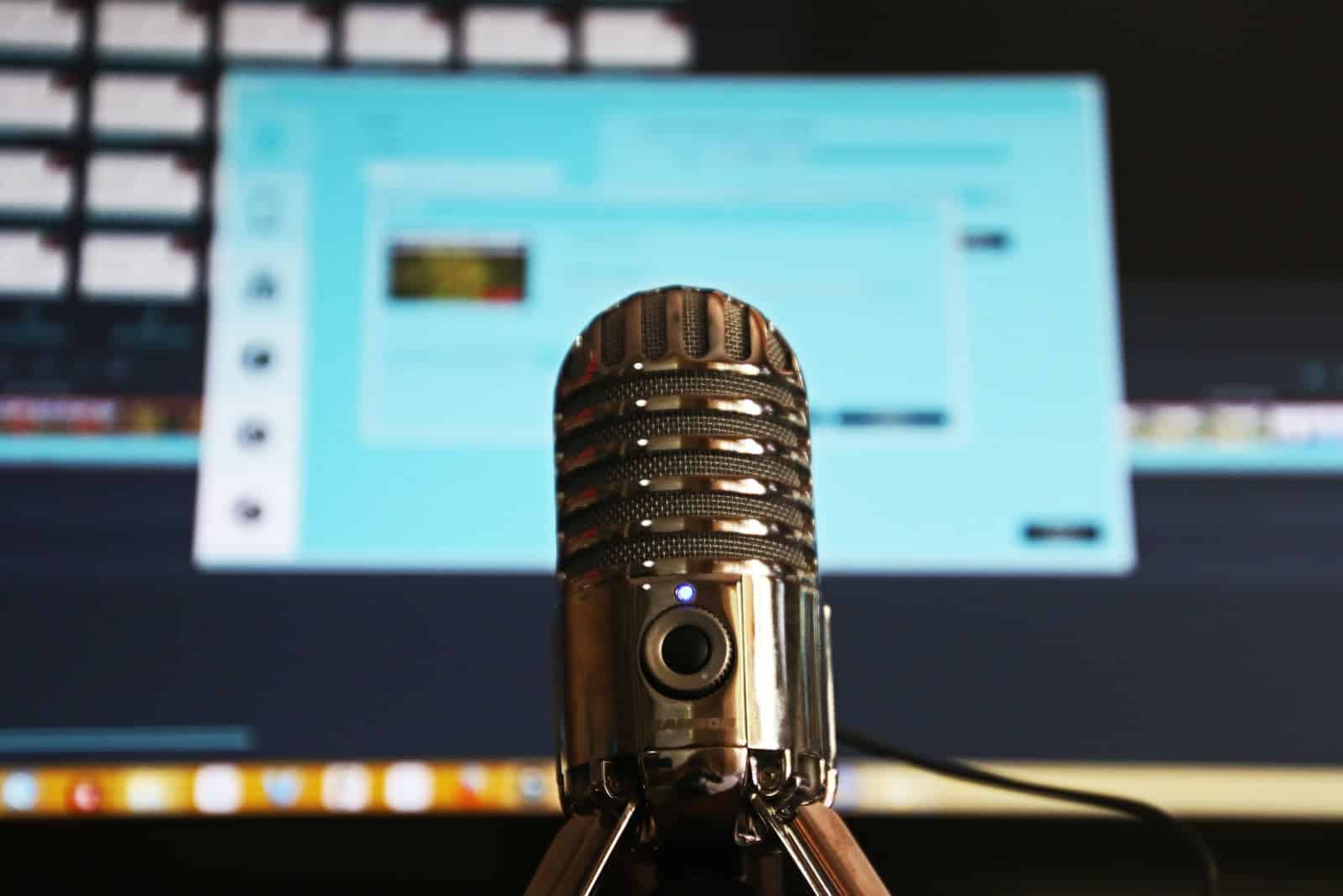 Microphone in front of a computer screen ready to record a podcast for a startup business.
