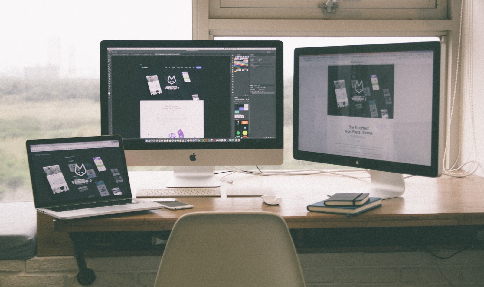 A freelancer’s desk with three screens ready to design a graphic for Instagram.