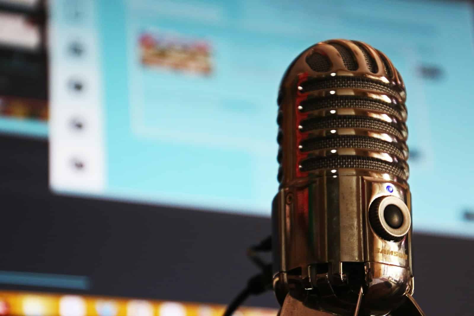 Microphone in front of a computer screen ready to record a podcast.